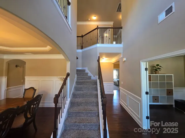 a view of a hallway with wooden floor and stairs
