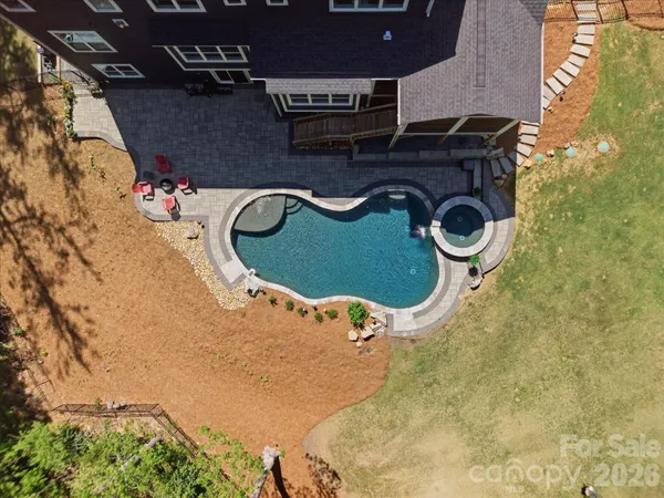 an aerial view of residential house with outdoor space and trees all around