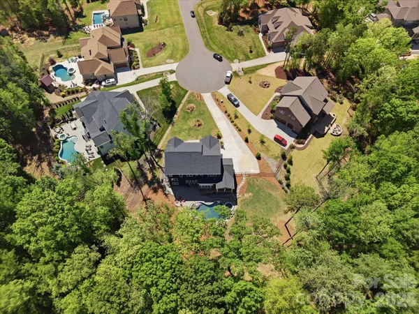 an aerial view of residential house with outdoor space and trees all around