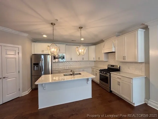 a kitchen with stainless steel appliances granite countertop a sink a stove and a refrigerator