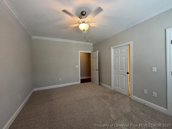 an empty room with closet and a ceiling fan