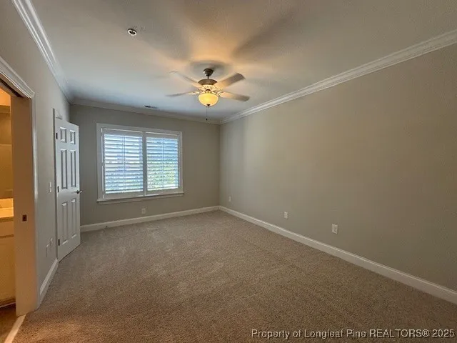 an empty room with windows and chandelier fan