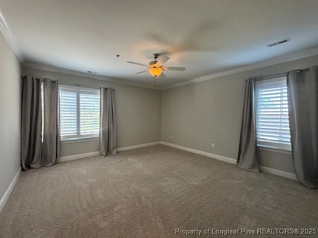 an empty room with closet and a ceiling fan
