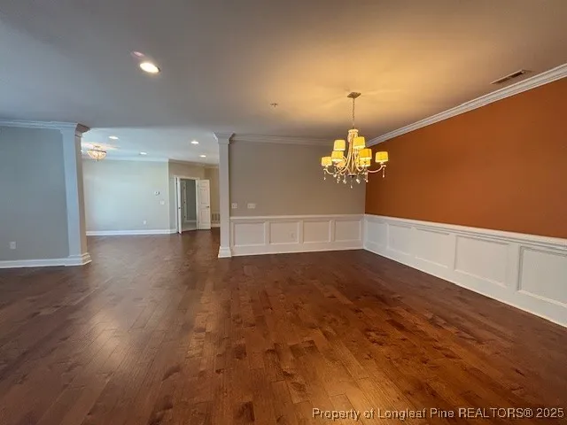 a view of a room with wooden floor chandelier and a window