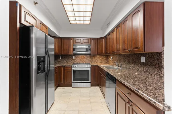 a kitchen with stainless steel appliances granite countertop a stove a refrigerator and a sink