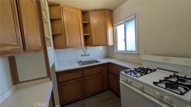a kitchen with stainless steel appliances a sink stove and cabinets