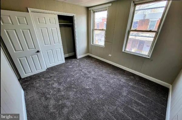 a view of an empty room with brick walls and stairs
