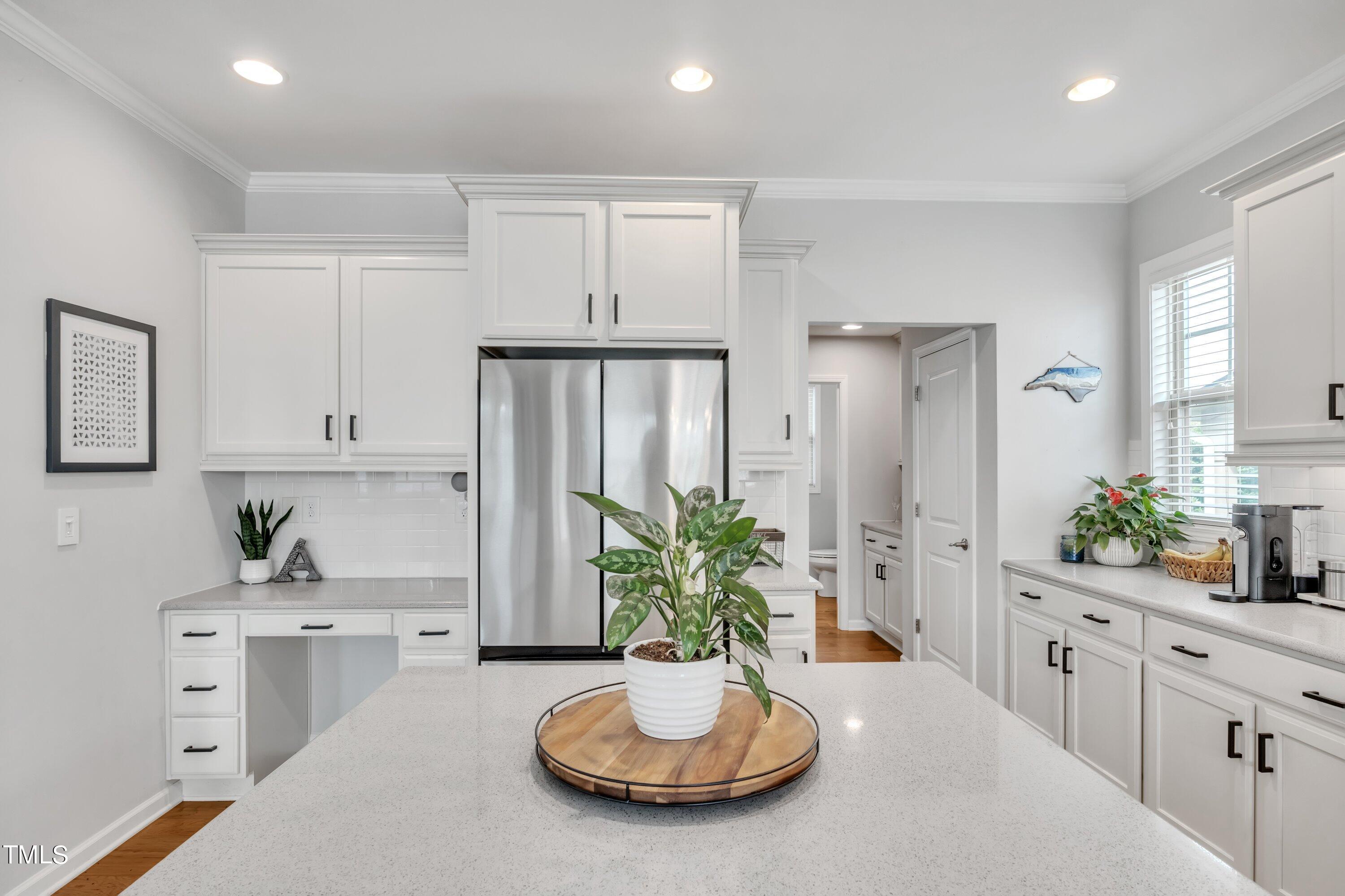 844 Wildflower Ridge Road Wake Forest, NC 27587 - Photo 19 of 66 a kitchen with a refrigerator and white cabinets