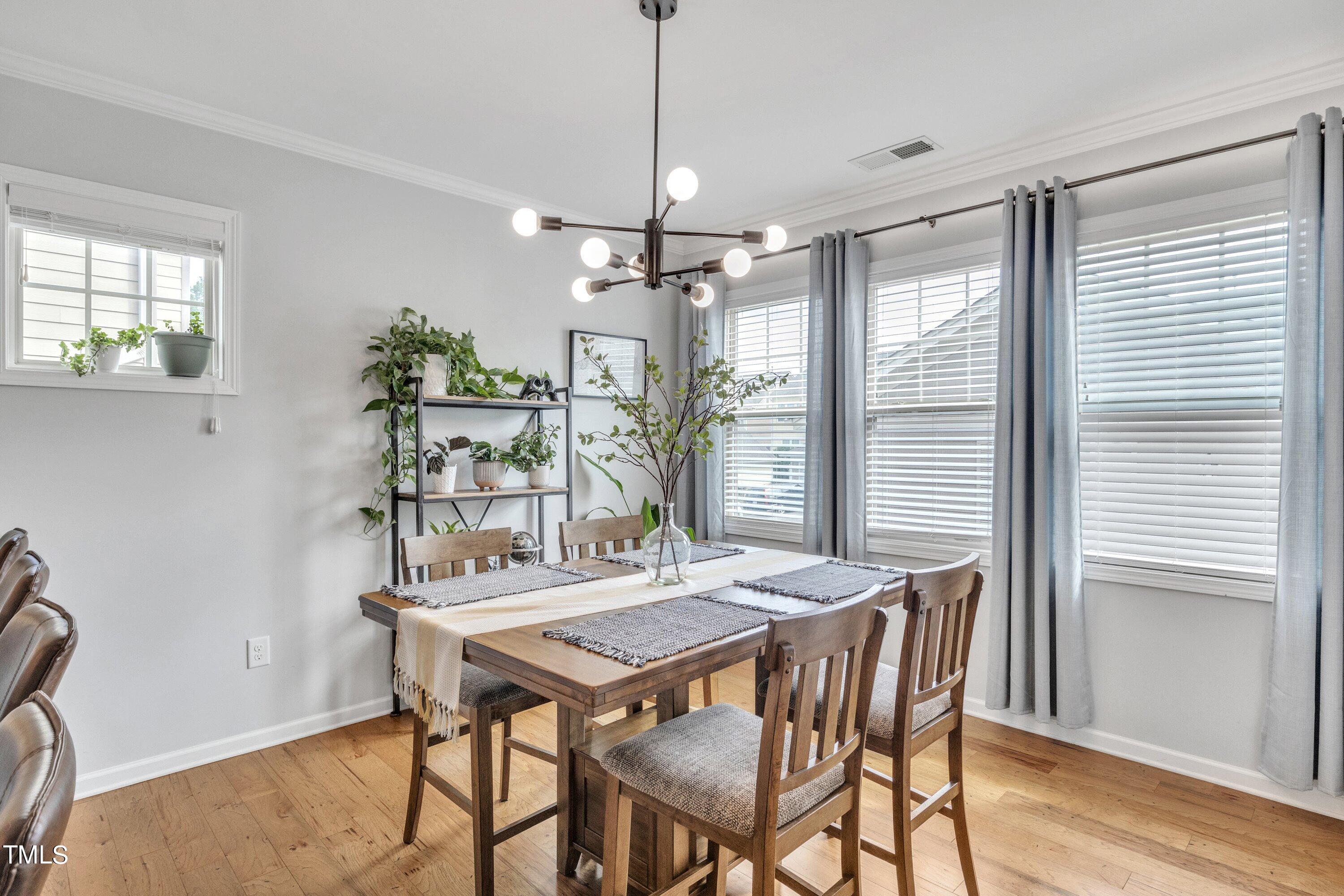 844 Wildflower Ridge Road Wake Forest, NC 27587 - Photo 24 of 66 a view of a dining room with furniture window and wooden floor