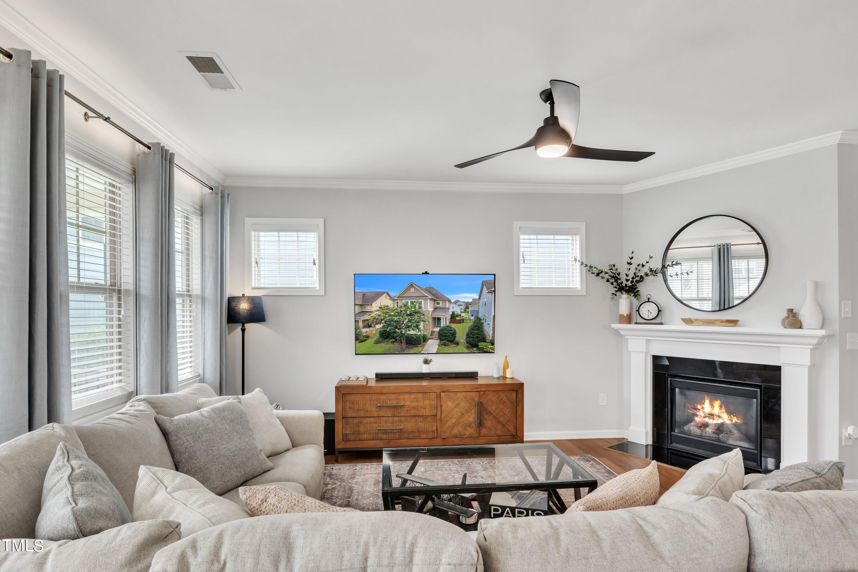 844 Wildflower Ridge Road Wake Forest, NC 27587 - Photo 27 of 66 a living room with furniture a fireplace and a flat screen tv