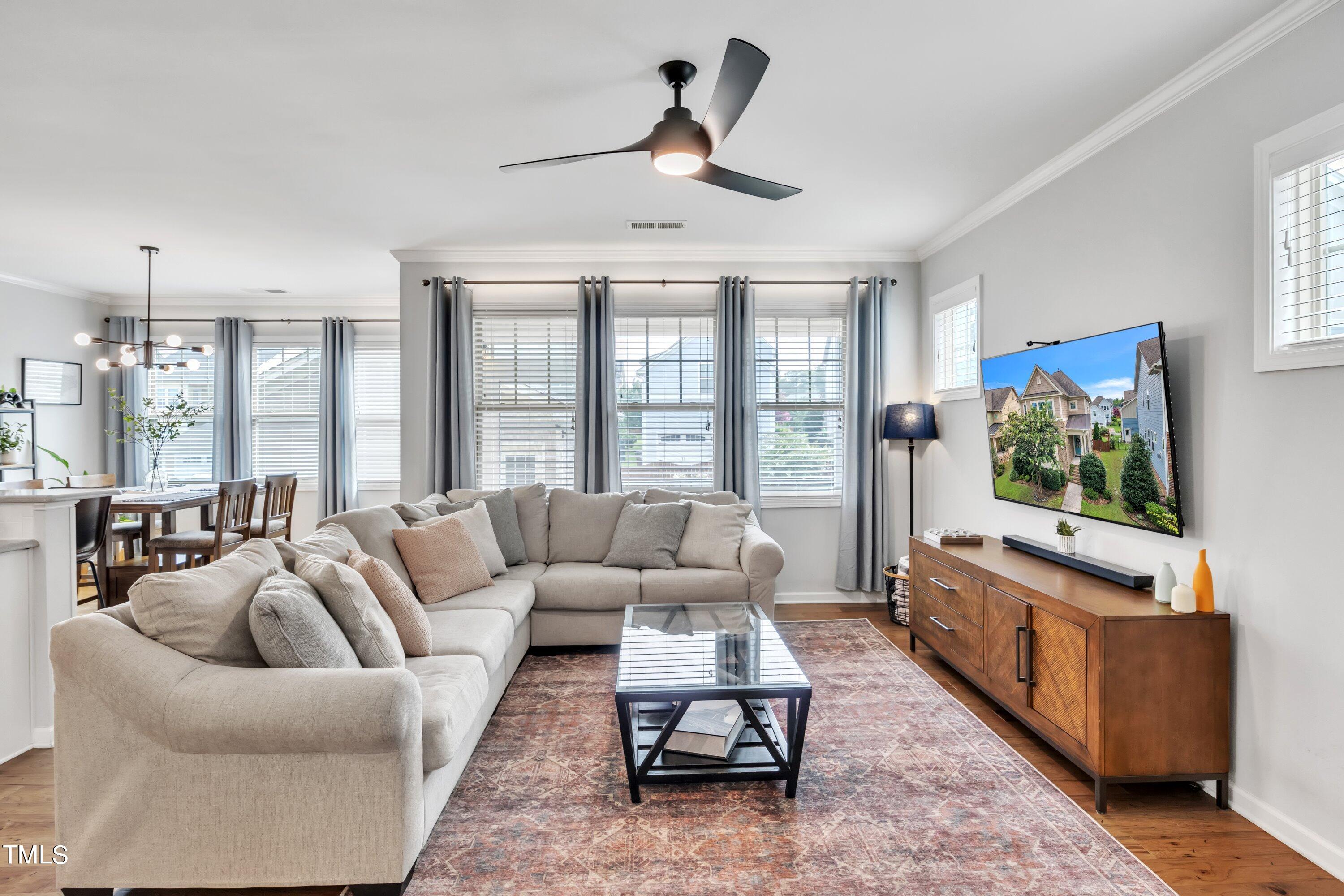 844 Wildflower Ridge Road Wake Forest, NC 27587 - Photo 30 of 66 a living room with furniture a flat screen tv and a large window