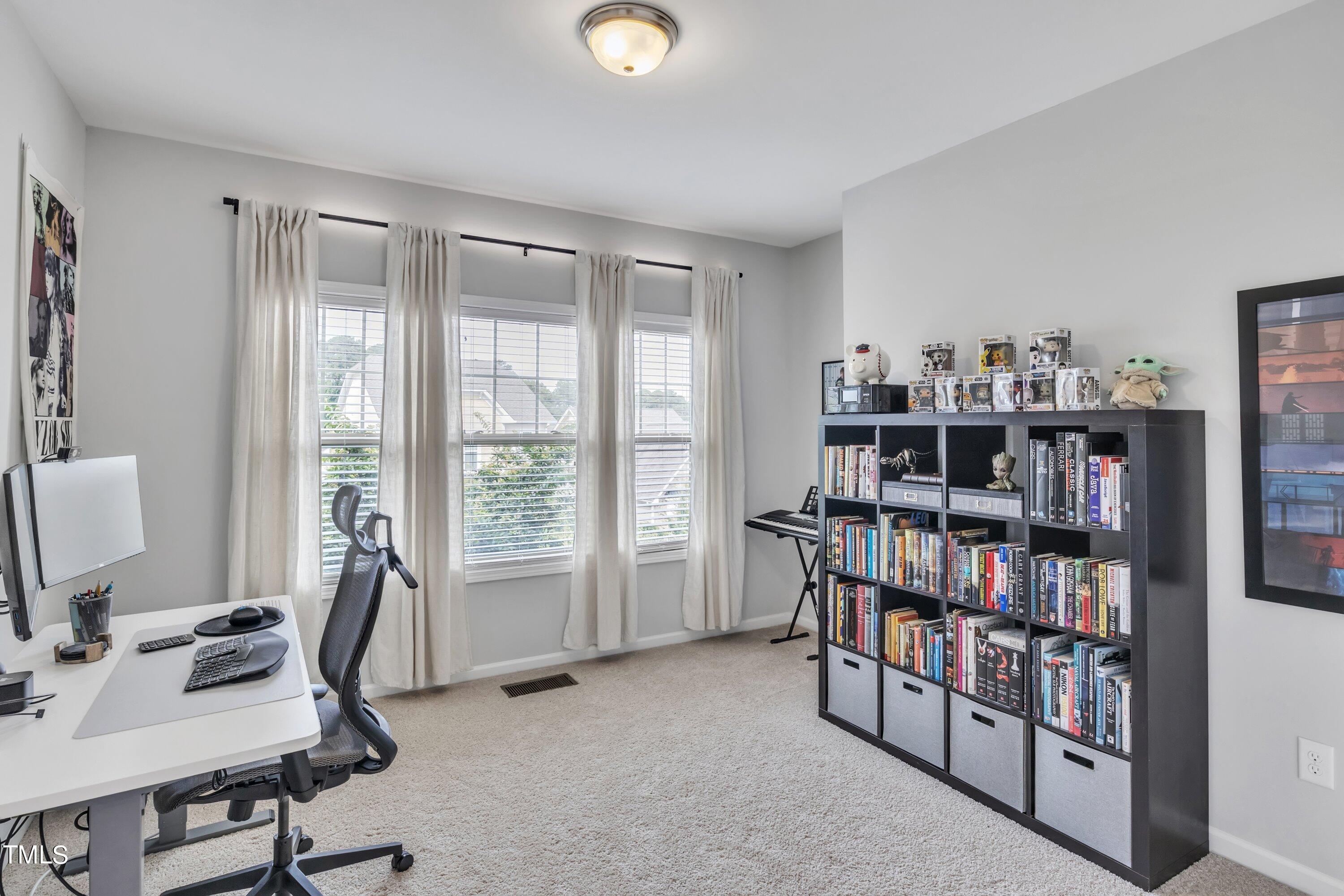 844 Wildflower Ridge Road Wake Forest, NC 27587 - Photo 35 of 66 a view of a workspace with furniture and a bookshelf