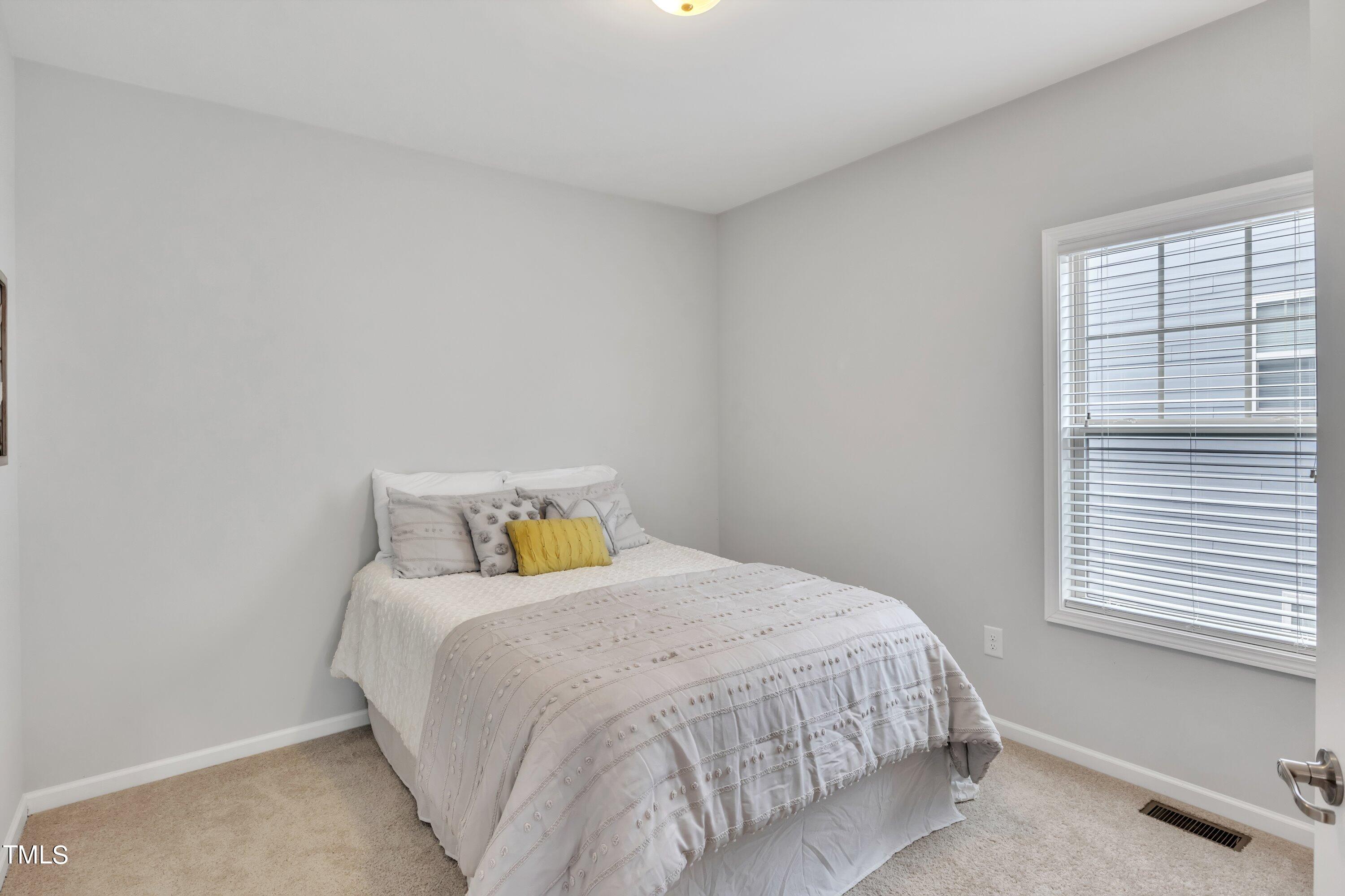 844 Wildflower Ridge Road Wake Forest, NC 27587 - Photo 38 of 66 a bedroom with a bed and a window