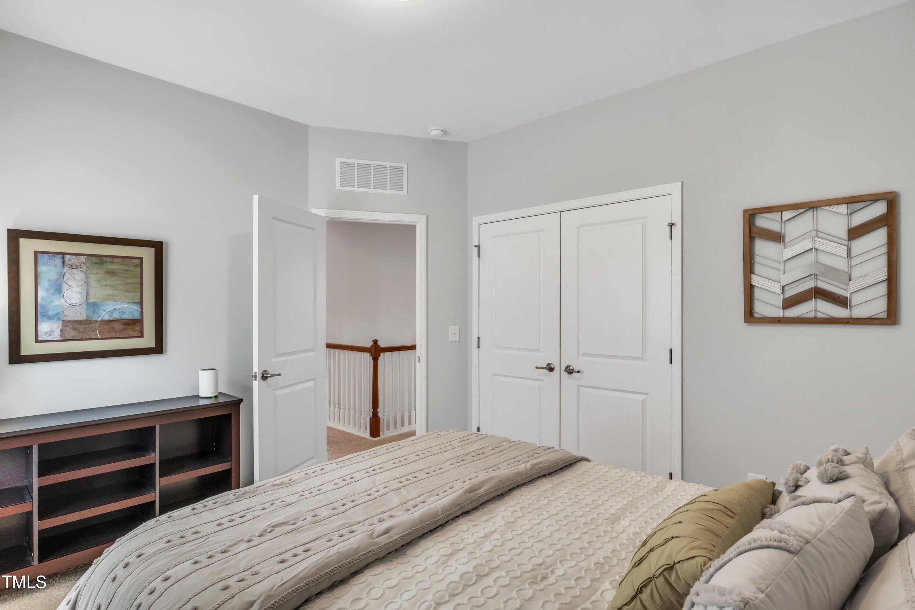 844 Wildflower Ridge Road Wake Forest, NC 27587 - Photo 39 of 66 a bedroom with a bed and a painting on the wall