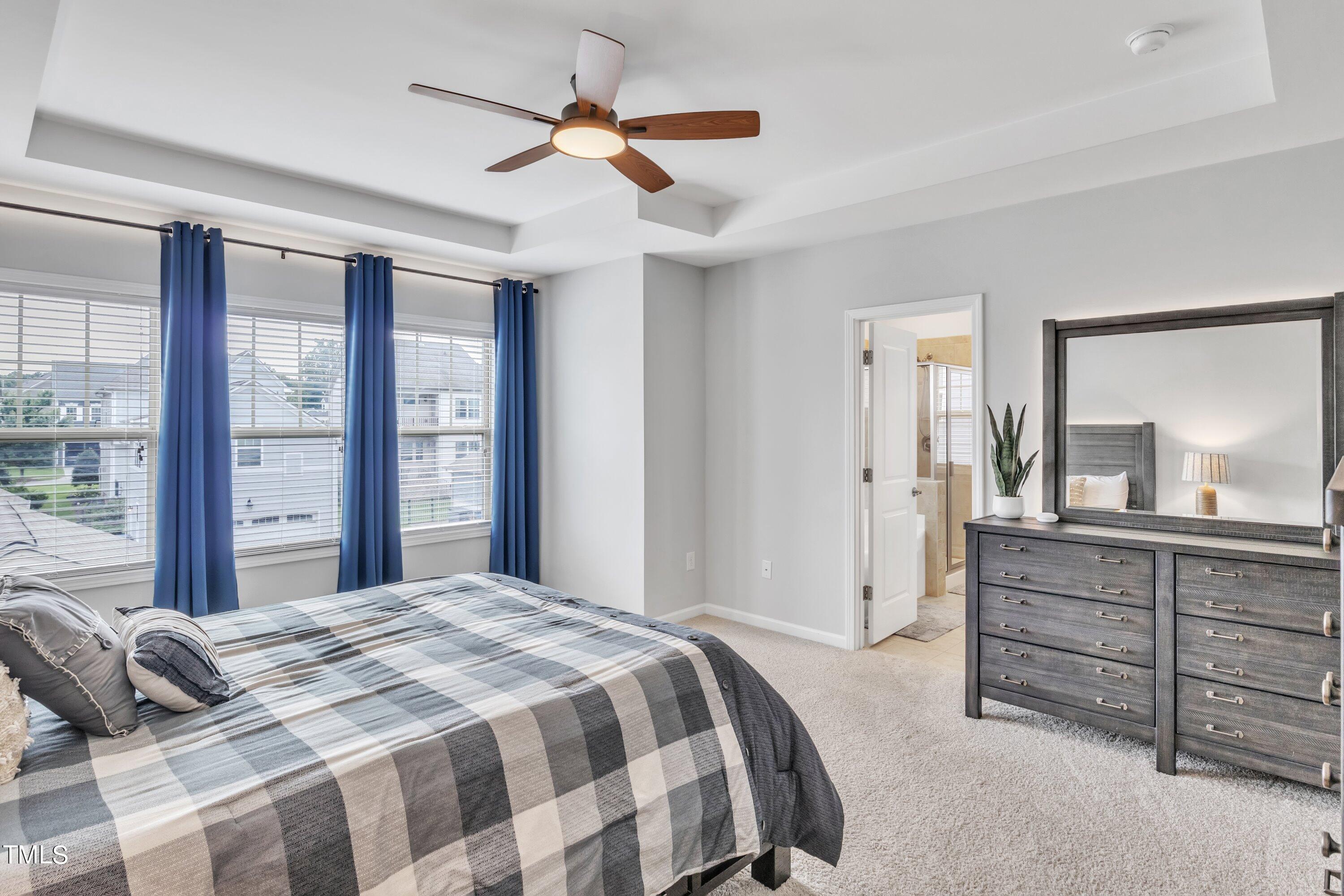 844 Wildflower Ridge Road Wake Forest, NC 27587 - Photo 41 of 66 a bedroom with a large bed and a chandelier