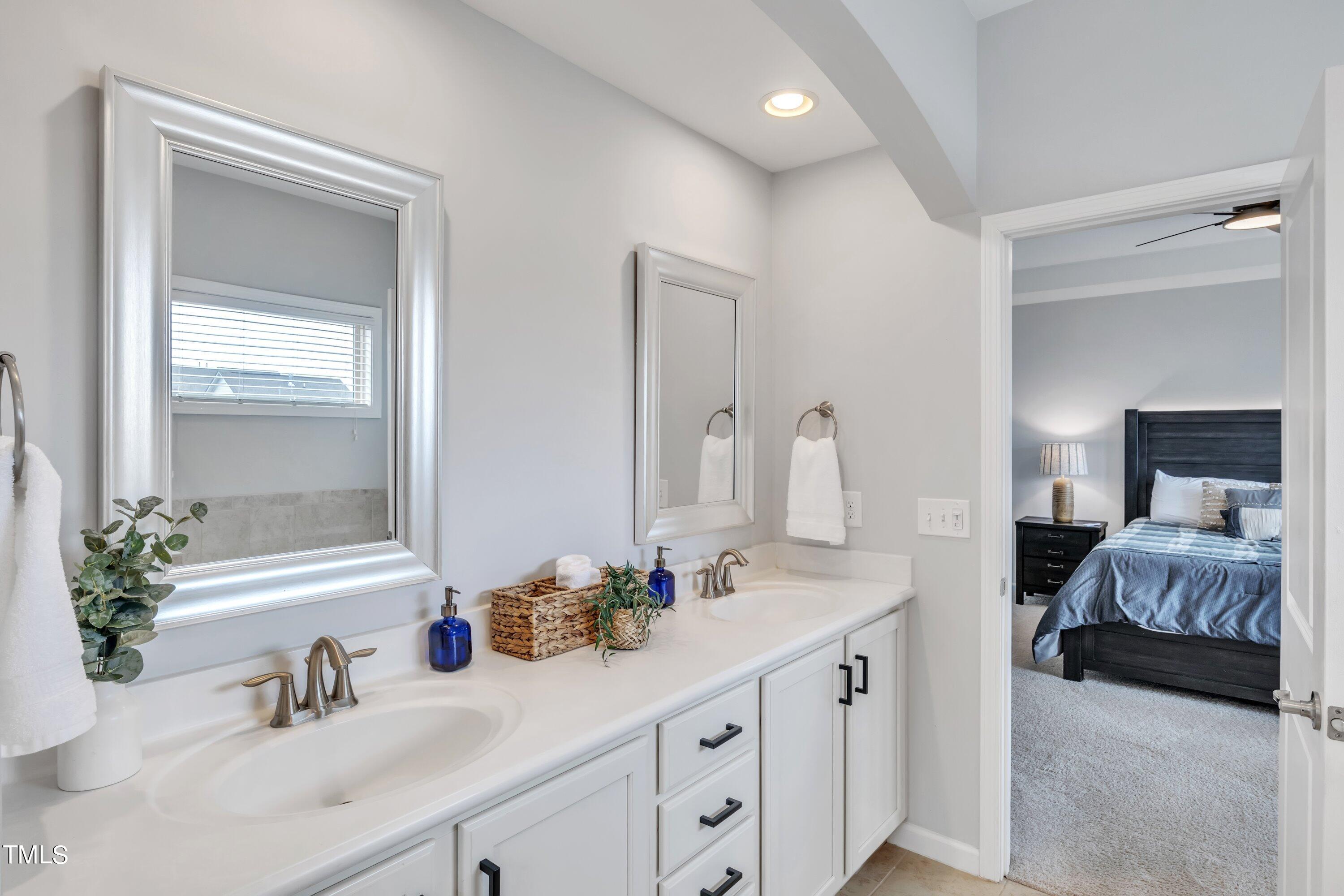 844 Wildflower Ridge Road Wake Forest, NC 27587 - Photo 44 of 66 a en suite bathroom with a double vanity sink and a mirror