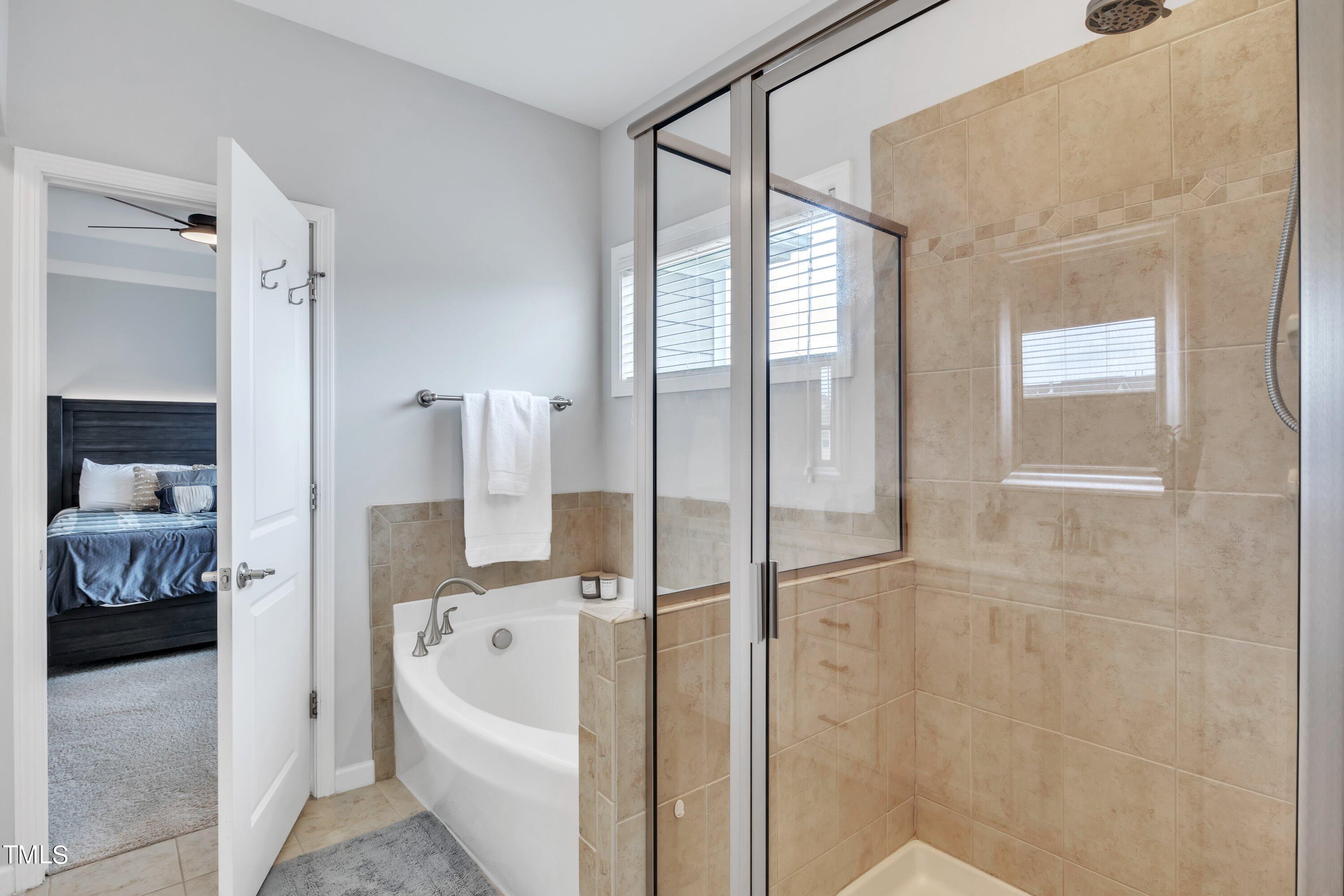 844 Wildflower Ridge Road Wake Forest, NC 27587 - Photo 45 of 66 a bathroom with a bathtub and a shower
