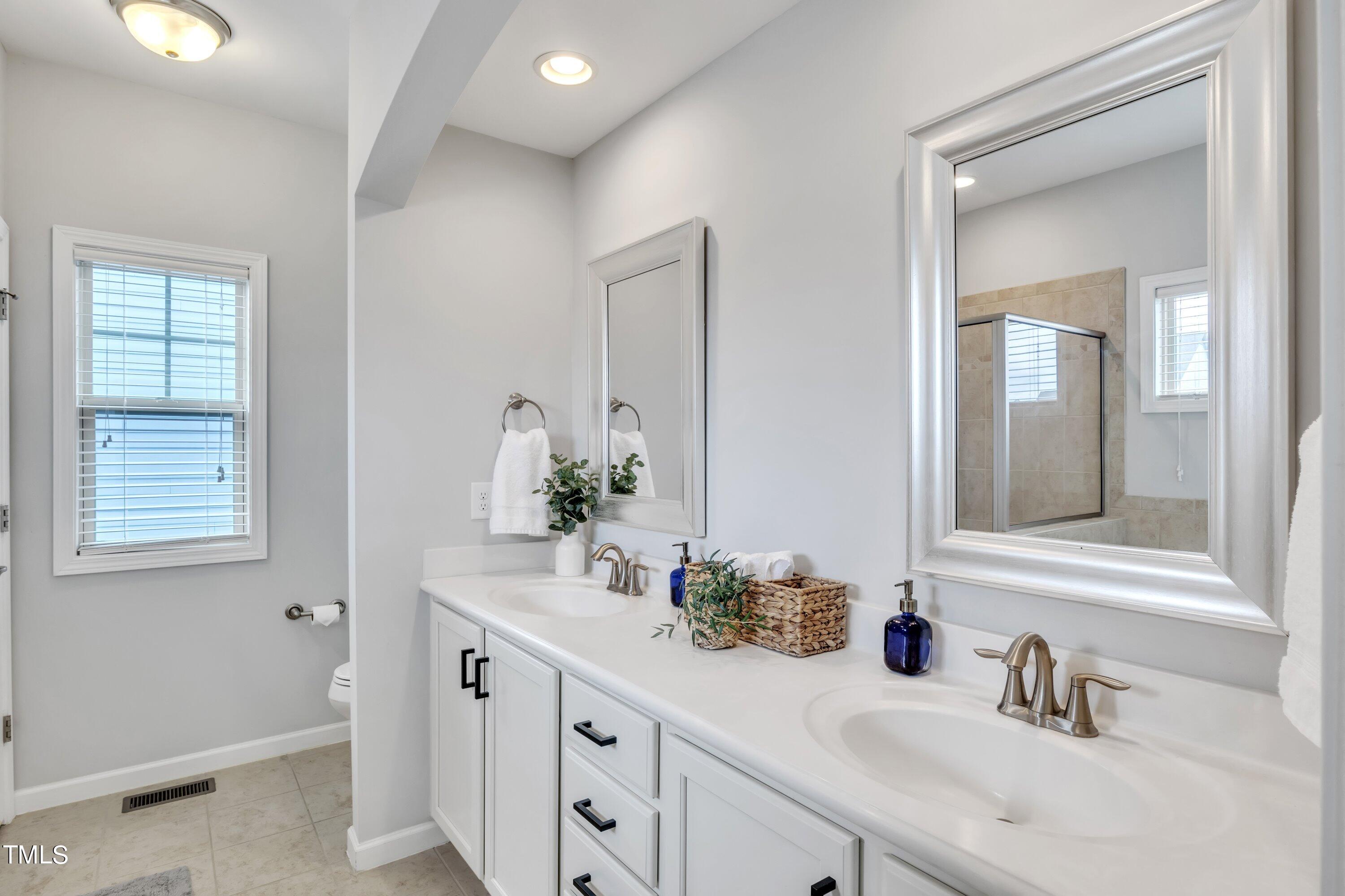 844 Wildflower Ridge Road Wake Forest, NC 27587 - Photo 46 of 66 a bathroom with a sink and a mirror