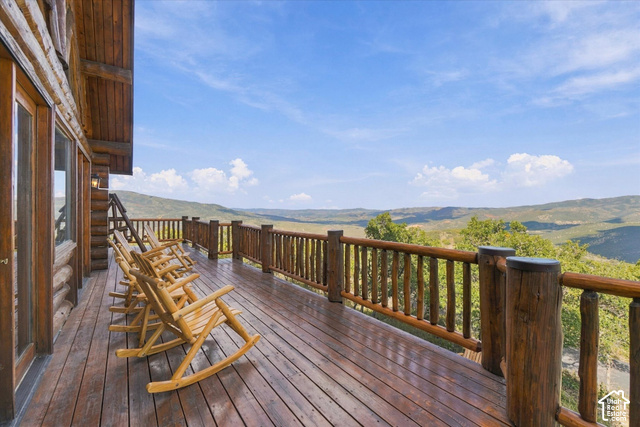1701 Oak Road Coalville, UT 84017 - Photo 10 of 71 Expansive outdoor deck featuring wood-plank flooring, a rustic wood railing, and a mountainous backdrop