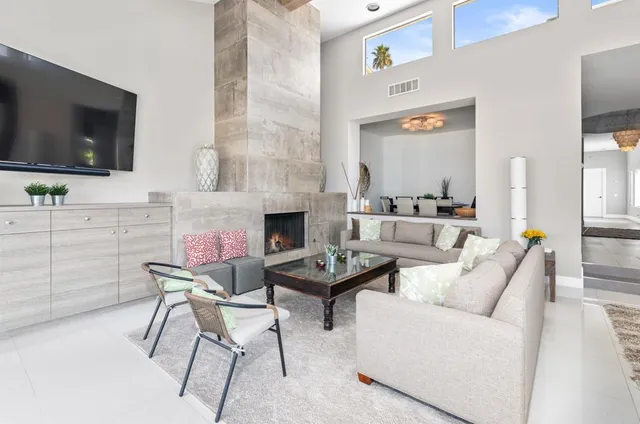a living room with furniture a flat screen tv and a fireplace