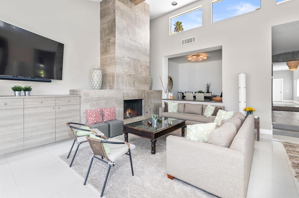 54877 Inverness Way La Quinta, CA 92253 - Photo 18 of 60 a living room with furniture a flat screen tv and a fireplace