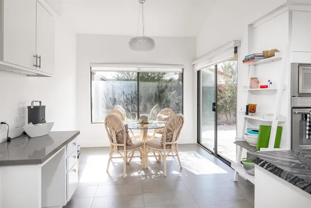 a dining room with furniture a chandelier and wooden floor