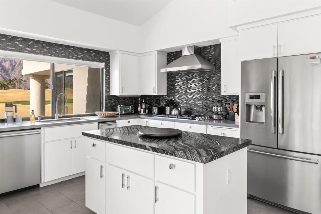 54877 Inverness Way La Quinta, CA 92253 - Photo 21 of 60 a kitchen with granite countertop a sink stove and refrigerator