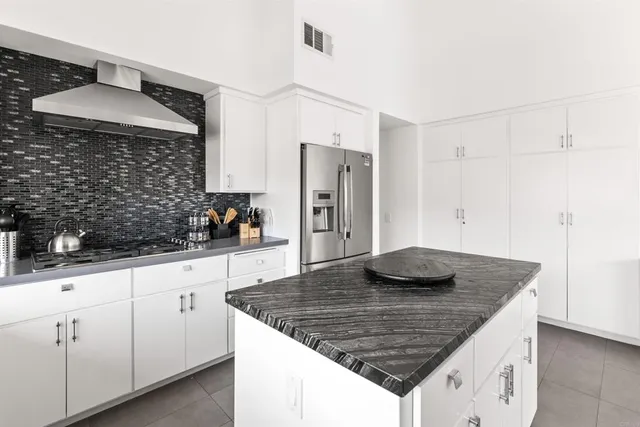 a kitchen with stainless steel appliances granite countertop a sink dishwasher a refrigerator and a stove