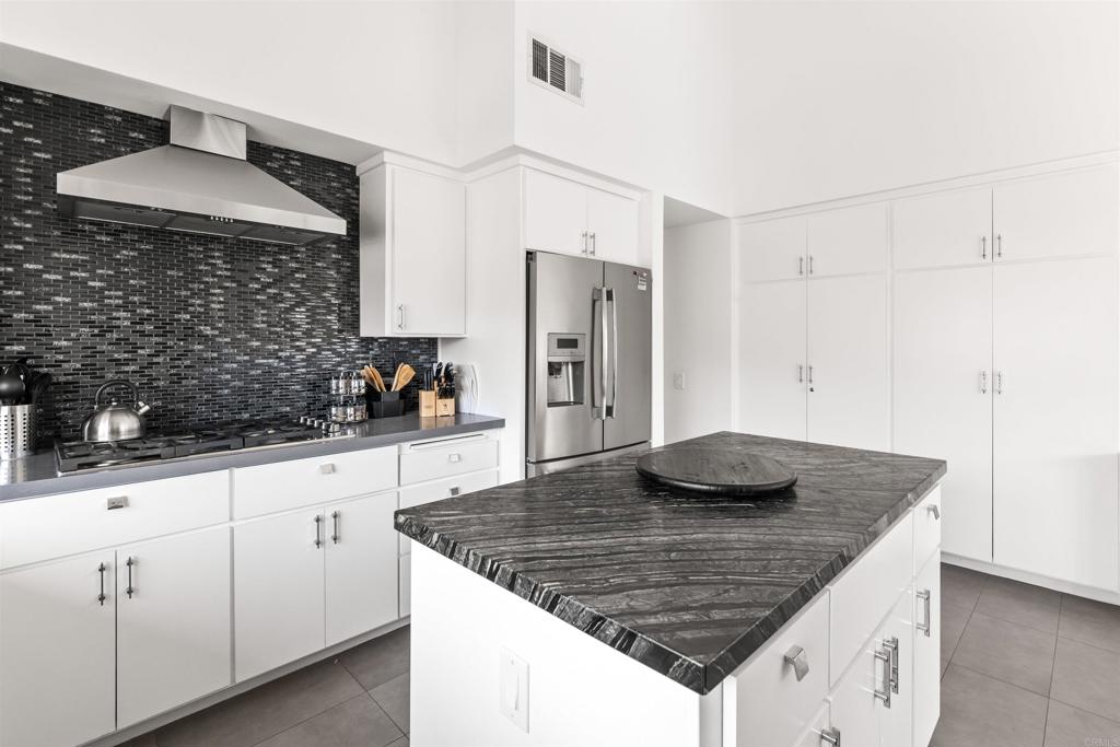 54877 Inverness Way La Quinta, CA 92253 - Photo 22 of 60 a kitchen with stainless steel appliances granite countertop a sink dishwasher a refrigerator and a stove