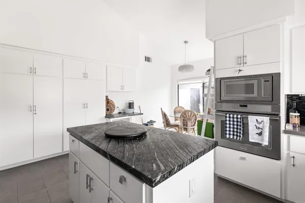 a kitchen with granite countertop a sink a stove and cabinets