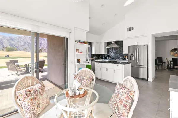 a kitchen with stainless steel appliances granite countertop a stove a kitchen island a dining table and chairs