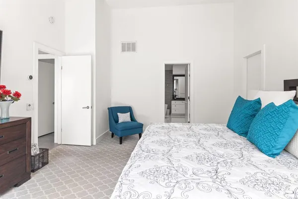 a bedroom with a bed and large flat screen tv