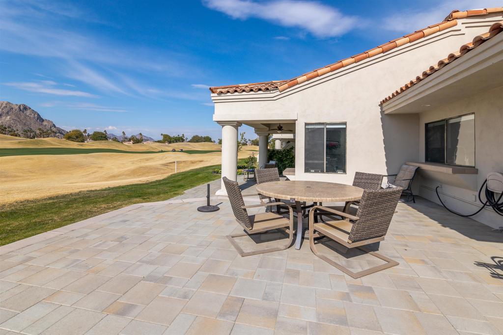 54877 Inverness Way La Quinta, CA 92253 - Photo 41 of 60 a view of a patio with lawn chairs floor to ceiling window and an outdoor space