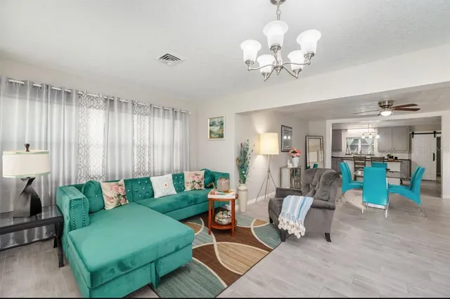a living room with furniture a chandelier and a window