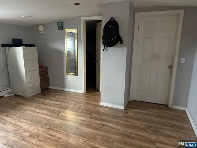 an empty room with wooden floor and closet