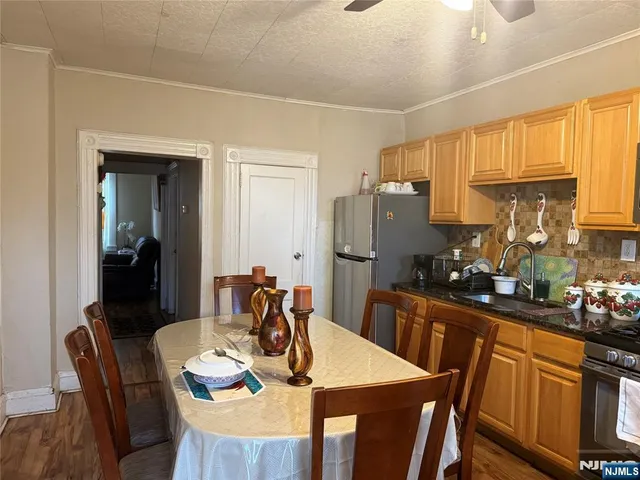a kitchen with stainless steel appliances granite countertop a dining table and chairs