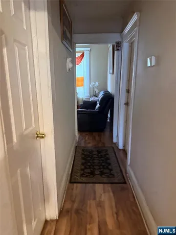 a bedroom with wooden floor closet and a rug