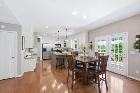 a view of a dining room and livingroom with furniture wooden floor a rug and a view
