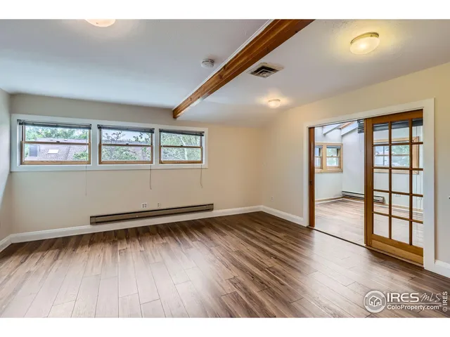 wooden floor in an empty room with a window