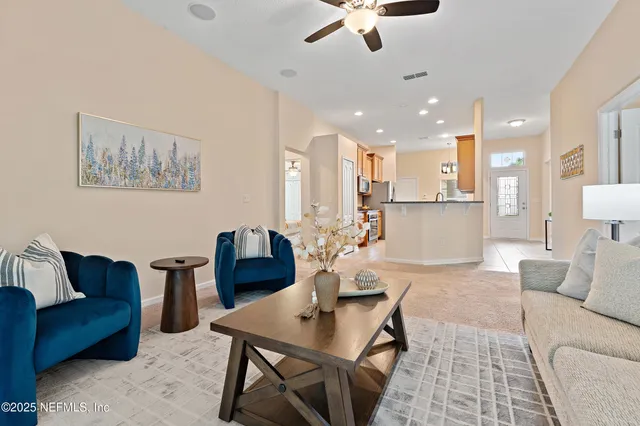 a living room with furniture and kitchen view