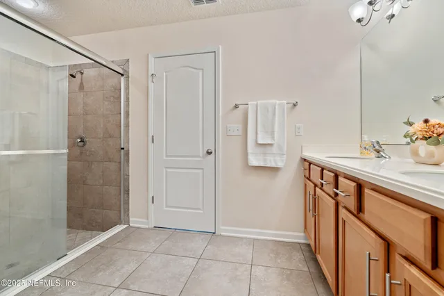 a bathroom with a shower sink and mirror