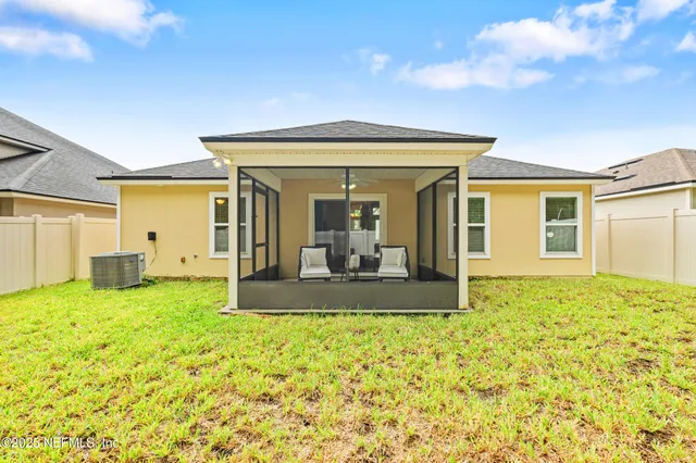 a view of a house with a large tree and a yard
