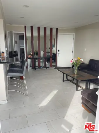 a living room with couches and a dining table with garden view