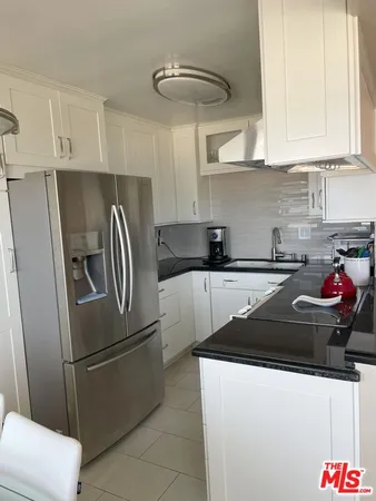 a kitchen with stainless steel appliances granite countertop a refrigerator a sink a stove and dishwasher