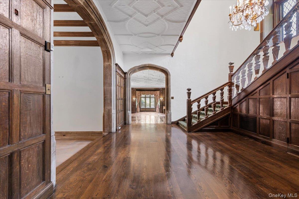 127 Horseshoe Road Mill Neck, NY 11765 - Photo 13 of 48 Foyer entrance featuring arched walkways, wood finished floors, stairway, and a chandelier