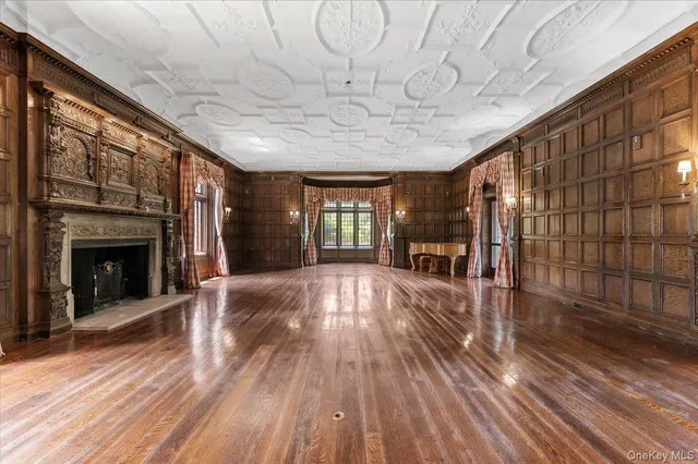 a view of empty room with wooden floor and fireplace