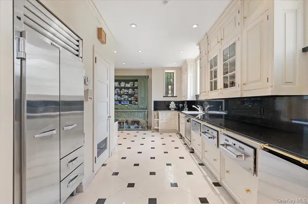 a kitchen with stainless steel appliances a sink a stove a dining table and chairs