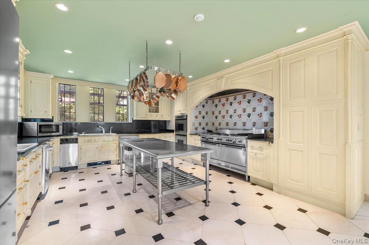 127 Horseshoe Road Mill Neck, NY 11765 - Photo 27 of 48 a kitchen with stainless steel appliances a sink a stove a dining table and chairs