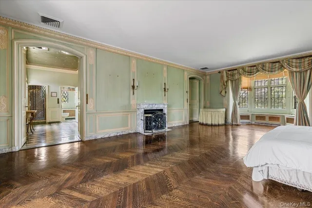 a spacious bedroom with a bed and wooden floor