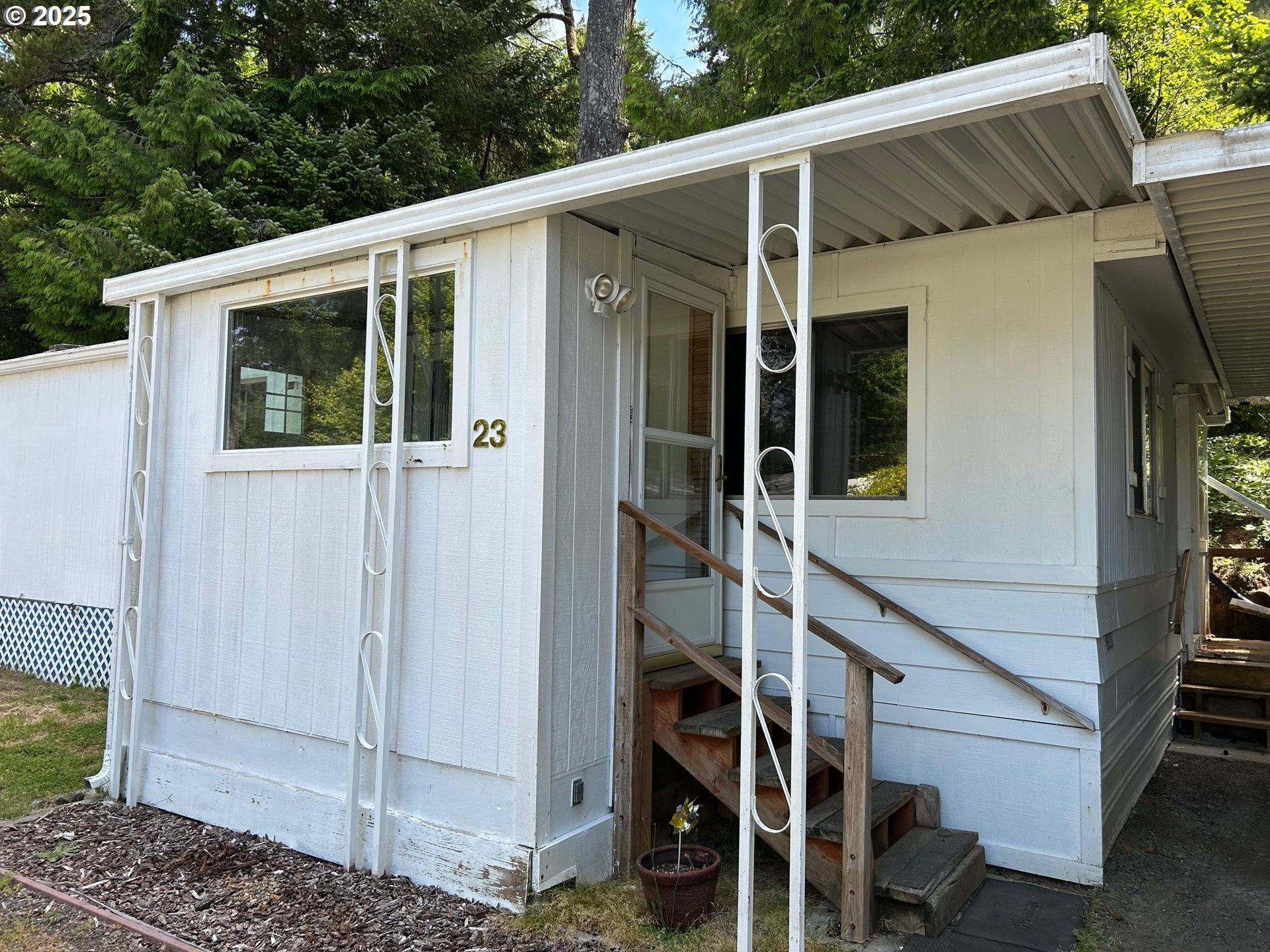 89510 Highway 101, Unit 23 Florence, OR 97439 - Photo 3 of 28 a view of a patio with table and chairs and floor to ceiling window